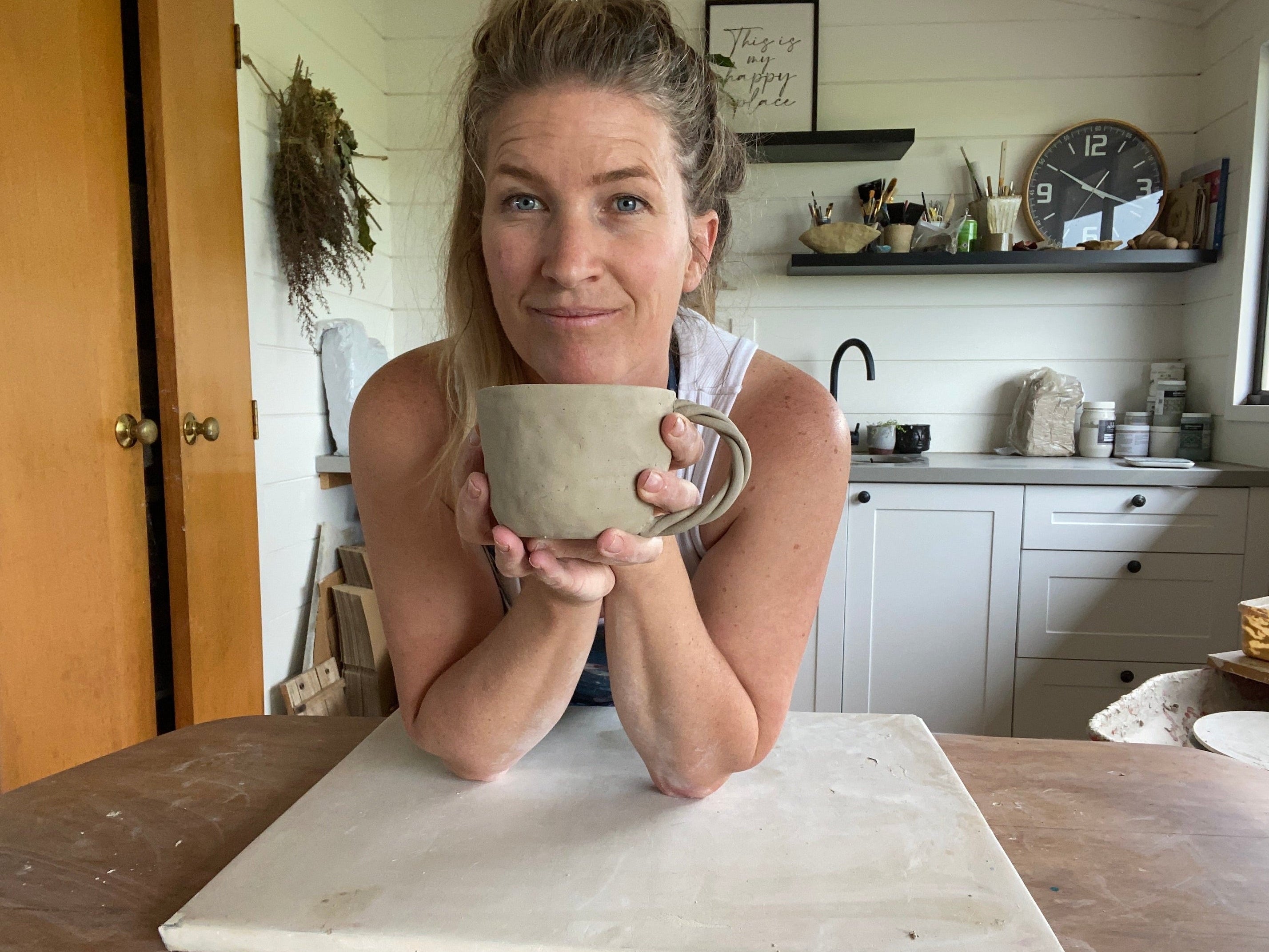 Women holding hand made pottery mug